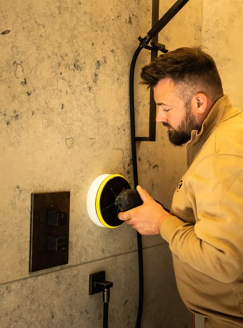 Mitarbeiter poliert Steinwand